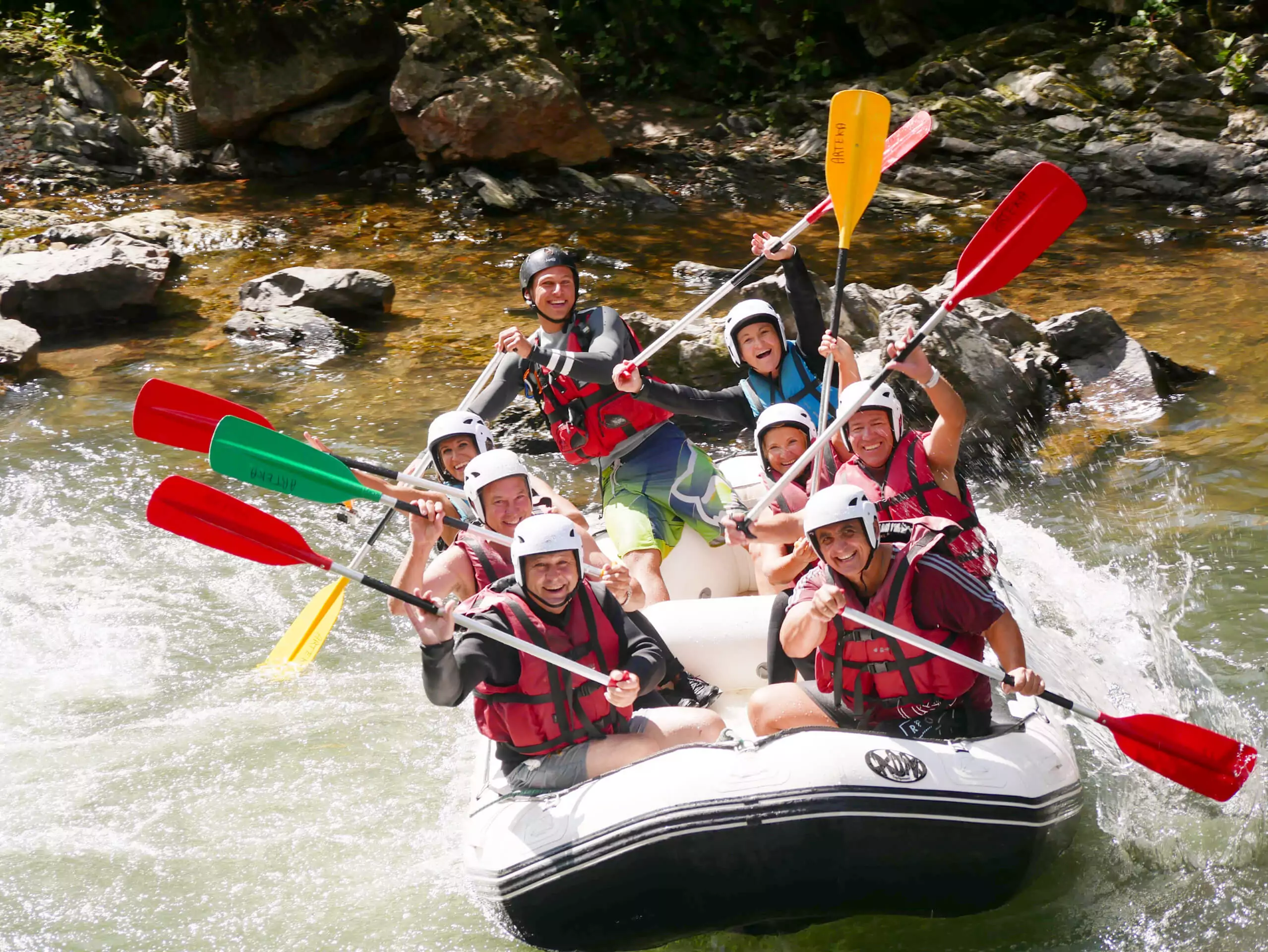 Rafting sur la Nive au Pays basque : 8 participants souriants dans un bateau gonflable.