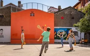 Initiation à la pelote basque. Garçon tape dans la balle avec sa pala © Mathieu Prat